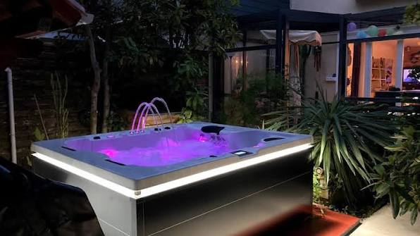 Spa éclairé en rose dans un patio